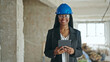© Krakenimages.com - African american woman architect smiling confident using touchpad at construction site