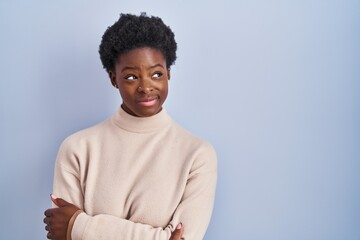 Poster - African american woman standing over blue background smiling looking to the side and staring away thinking.