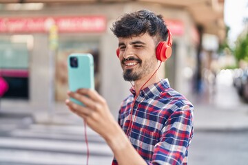 Sticker - Young hispanic man smiling confident having video call at street