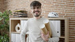 © Krakenimages.com - Young hispanic man architect holding blueprints at office