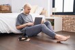 © Krakenimages.com - Young caucasian man using laptop sitting on floor at bedroom