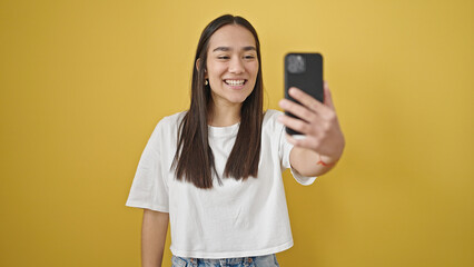 Sticker - Young beautiful hispanic woman smiling confident making selfie by the smartphone over isolated yellow background