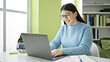 © Krakenimages.com - Young hispanic woman student using laptop smiling at library university