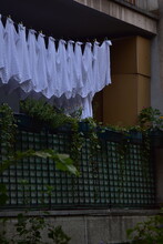 White Cloth Hanging On A Clothesline On The Balcony Of A Residential Building