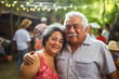 © Jasmina - Portrait of a happy smiling Mexican senior couple at family gathering outdoors