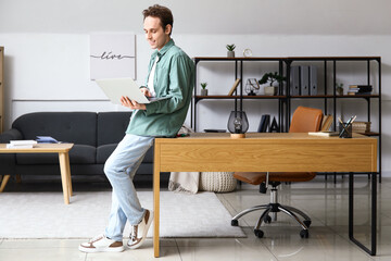 Poster - Male freelancer working with laptop in office