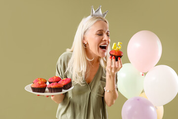 Poster - Mature woman with birthday muffins on green background