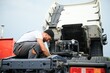 © Serhii - Mechanic repairing the truck in service.