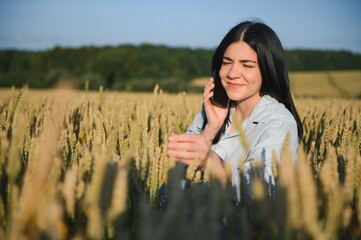 Wall Mural - Farmer woman working in wheat field at sunset.