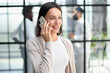 © Katsiaryna - Businesswoman with phone in modern office