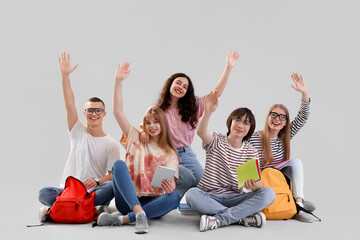 Wall Mural - Group of students sitting on light background