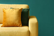 © Pixel-Shot - Cozy yellow armchair with cushion on green background, closeup
