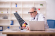 © Elnur - Old male doctor radiologist working in the clinic