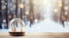 Snow Globe On Wooden Table With Winter Forest Background. Snow Globe With Trees On Winter Snowfall Background. 
