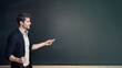passionate man teacher trying to write something on the blackboard with chalk. Copyspace. 