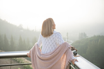 Wall Mural - asian woman stands with her back to camera and enjoys the view of forest. and looking mountain view in morning sunrise with copy space. trip and relaxing. Travel vacations and lifestyle concept.