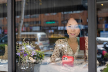 Poster - Woman use of mobile phone and sit inside cafe