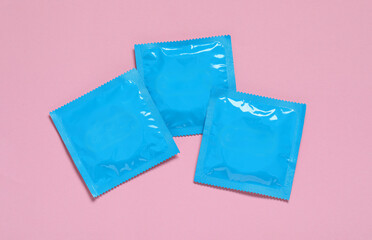 Wall Mural - Condom packages on pink background, flat lay. Safe sex