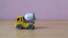 Industrial Mechanical Yellow Cement Truck Toy Drive On Wooden Table, Plaything For Kid Learning About Construction Site Work And Logistic Work, Copy Space