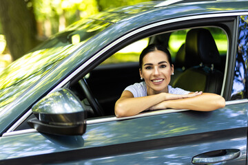 Wall Mural - Beautiful young smiling woman driving her car.