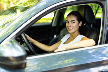 Wall Mural - Young beautiful smiling woman driving a car.