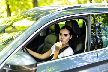 Wall Mural - Angry aggressive woman is clenching her fists and threatening from her car.