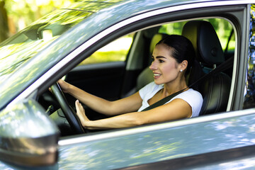 Wall Mural - Young woman hand pressing the horn button while driving a car through the road.