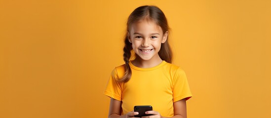 Canvas Print - Caucasian girl in violet T shirt on yellow background holds empty mobile phone