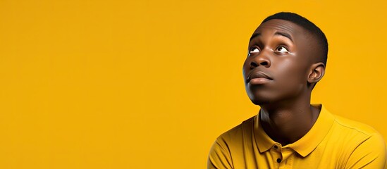 Sticker - Contemplative African teenager on yellow background gazes upwards pondering