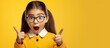© HN Works - Surprised girl with ponytails pointing at empty space for promotion on a yellow background