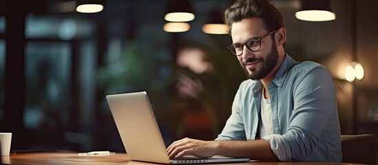 Canvas Print - Millennial businessman working at modern office using laptop smiling