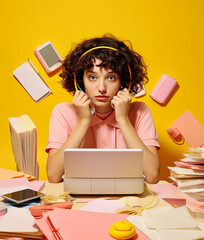 A young beautiful girl in the office buried with papers and books, bureaucracy and learning. Office hard work, a woman secretary for all duties.