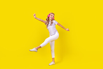 Sticker - Full length photo of positive woman dressed purple t-shirt listen energetic playlist in headphones isolated on yellow color background