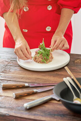 Wall Mural - Crop woman with delicious steak tartar in kitchen