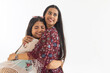 © IndiaPix - Portrait of two female friends embracing against white background