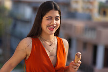Portrait of young woman eating ice cream in cone