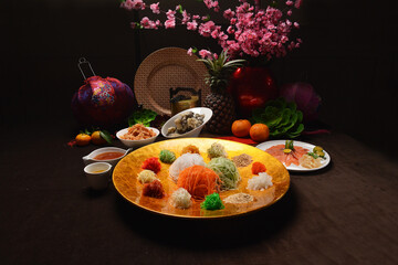 Wall Mural - fresh colourful asian festive vegetables salad lo hei yu sheng with smoked salmon, fish skin, cookies and sweet spicy sauce buffet corner for chinese new year halal food menu for banquet restaurant