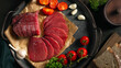Whole and sliced bresaola on a metal round tray with tomatoes, garlic and bread