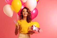 Satisfied Joyful Happy Young Woman Holding Helium Colored Balloons And Gift Box On A Pink Background, Congratulations On The Holiday Day