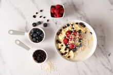 Healthy Oatmeal Breakfast With Berries, Banana And Raspberries.  Natural Ingredients. Flat Lay Design On Marble Background.