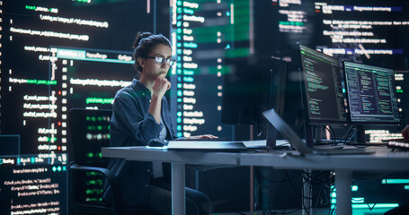 Leinwandbilder - Focused Woman Working on a Computer, Typing Lines of Code that Appear on Big Screens Surrounding her in a Monitoring Room. Female Programmer Creating Innovative Software Using AI Data and System