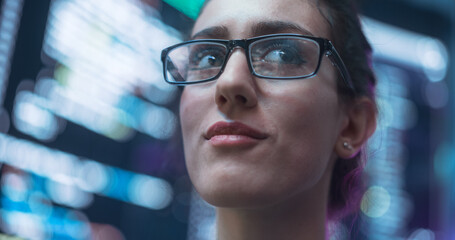 Leinwandbilder - Close Up Portrait of Smiling Woman Looking Around, Lines of Code Language Reflected on her Glasses from Big Display Screens Surrounding her. Professional Female Programmer Developing Software, Coding
