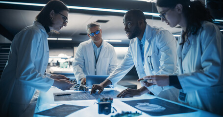 Poster - Diverse Team of Industrial Robotics Specialists Working on Innovative Prosthetic Hands in Advanced Research Facility. Young Engineers Discussing the Prototype, Testing Electronic Details.