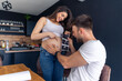 © DusanJelicic - An excited father-to-be holds an ultrasound to his partner's stomach and smiles because he is looking forward to having a baby soon