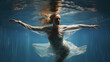 © JJ1990 - Beautiful woman swimming under water in a dancing stance creating a beautiful scene below the water surface