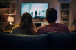 couple vue de dos en train de regarder une programme à la télévision dans leur salon sur grand écran