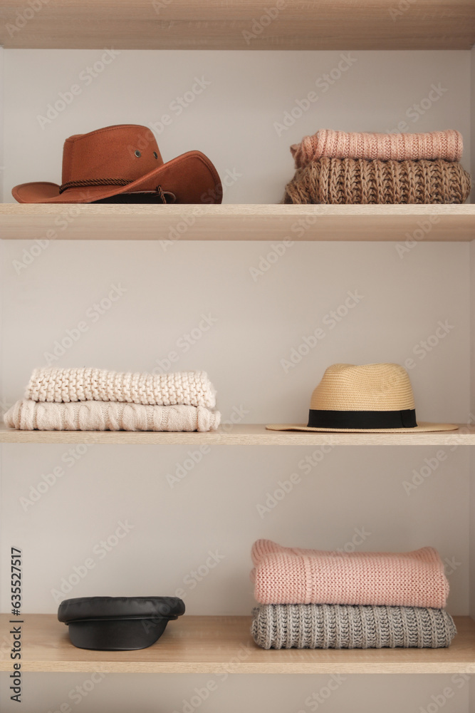 Shelves with stylish clothes and accessories in boutique, closeup