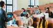 © ihorvsn - Rear of professor having speech in front of mixed-races students in VR glasses and laptops. Multiethnic males and females studying in technologic high school and listening to teacher at seminar.