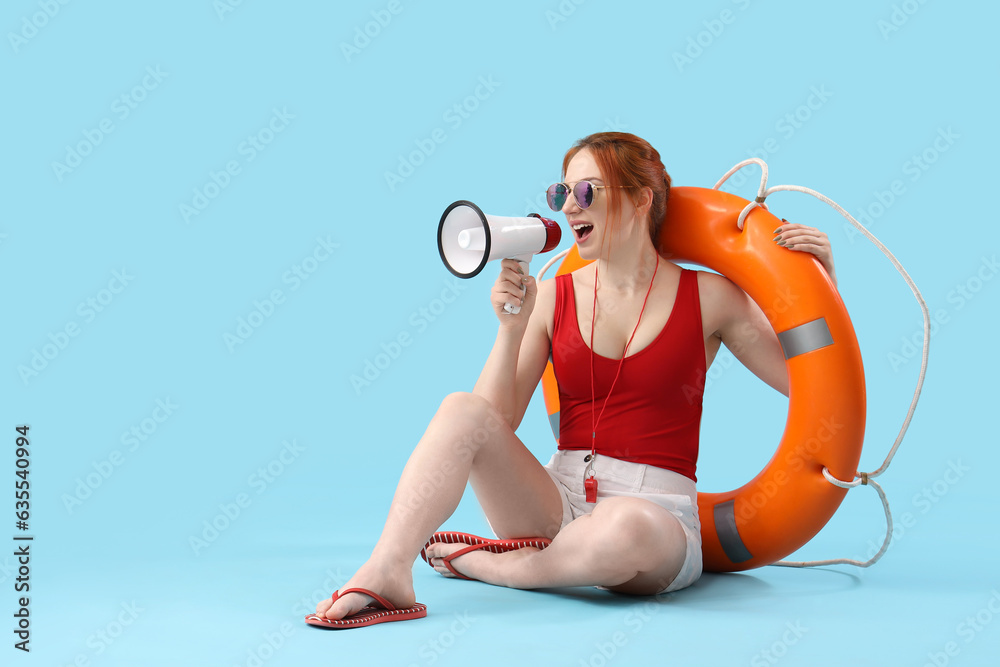 Female lifeguard with ring buoy shouting into megaphone on blue background