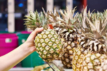 Wall Mural - Pineapple in hand of buyer in shop